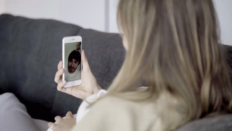 Back-view-of-future-mother-having-video-call-via-smartphone
